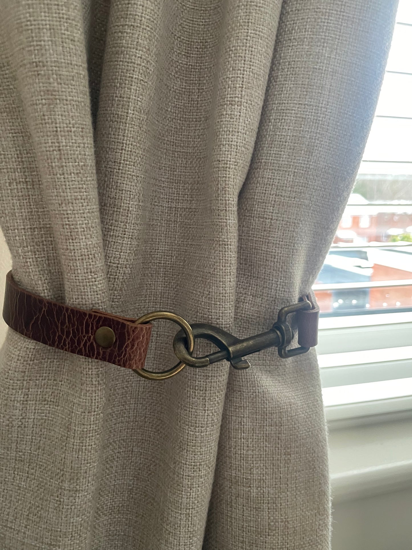 Antique brown leather curtain tie back with trigger clip fixing