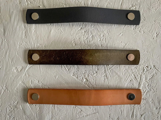 Handmade leather drawer pulls in various colours displayed on furniture