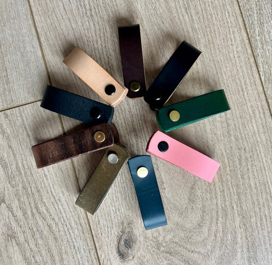Handmade leather drawer pulls in various colours on wooden furniture