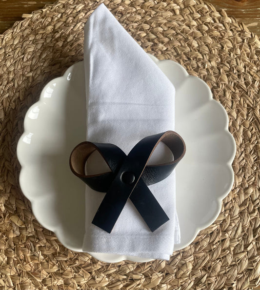 Elegant leather wedding favours including napkin rings and decorative bows for wedding table settings