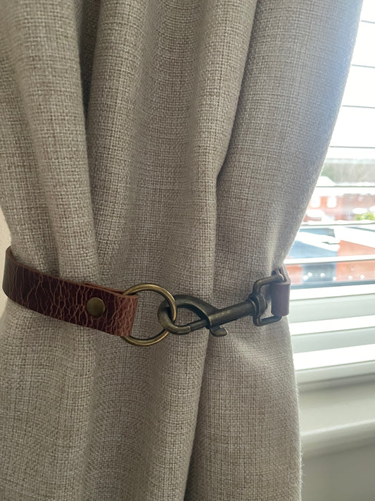 Antique brown leather curtain tie back with trigger clip fixing