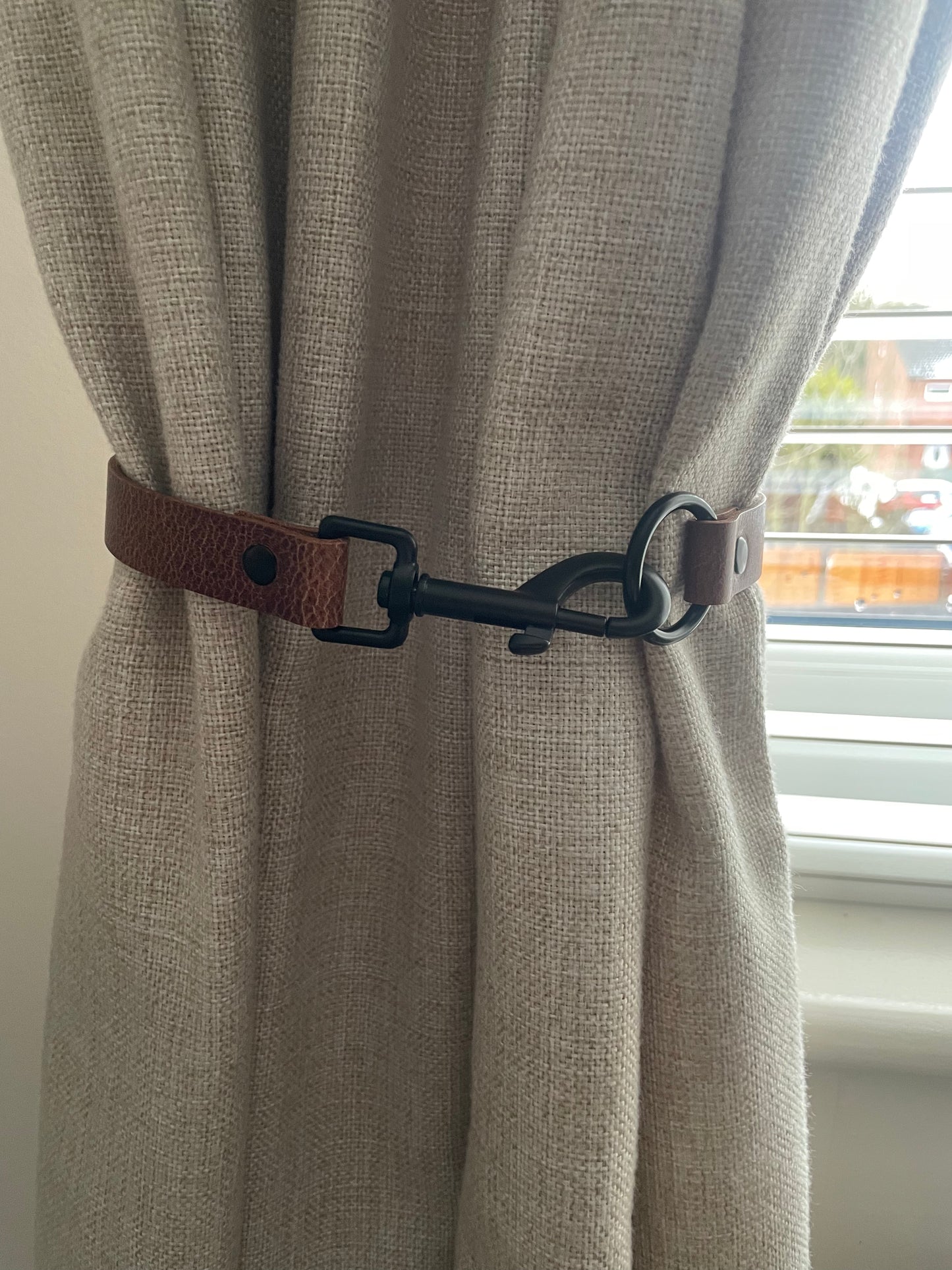 Antique brown leather curtain tie back with trigger clip fixing
