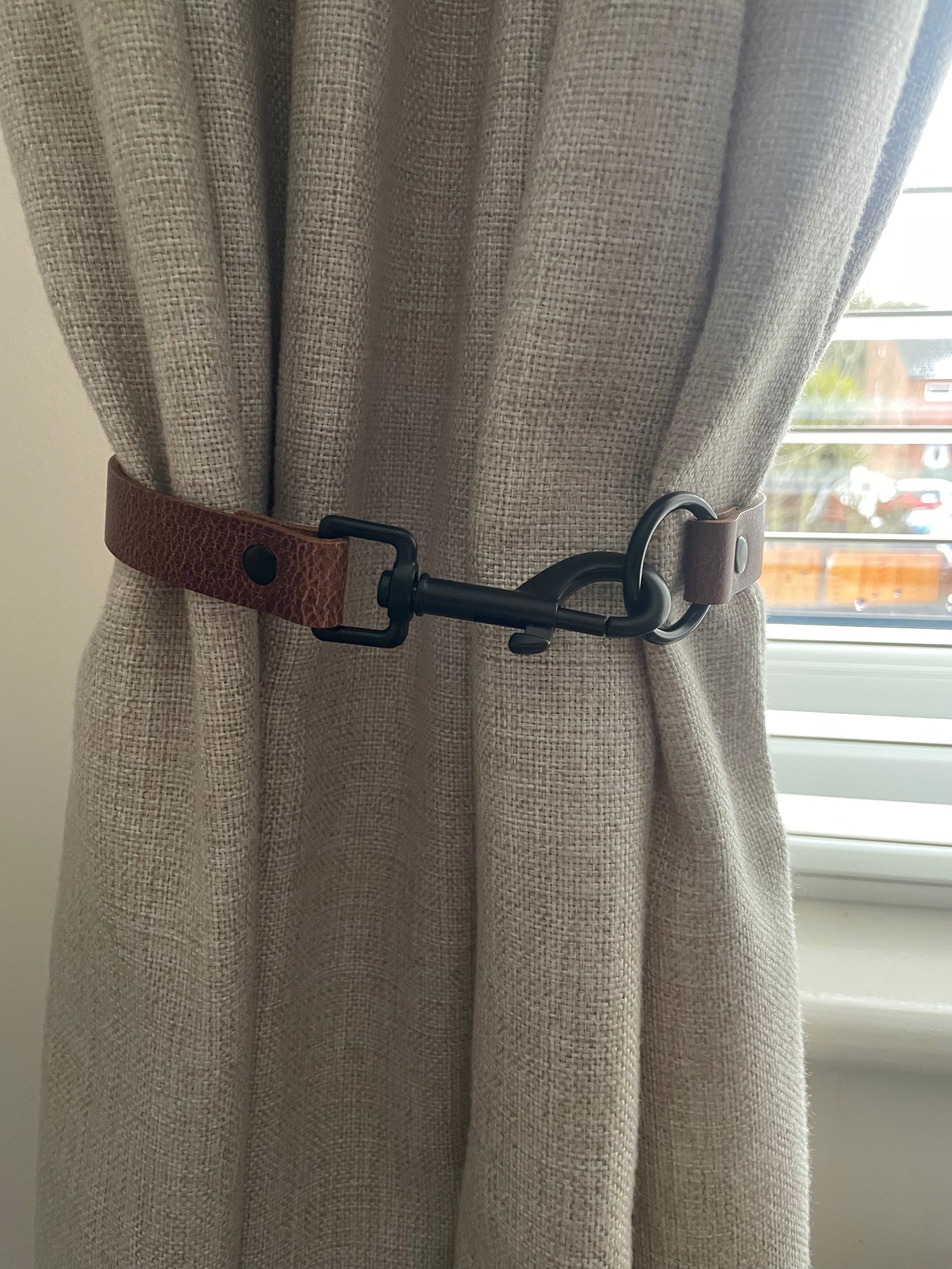 Antique brown leather curtain tie back with trigger clip fixing
